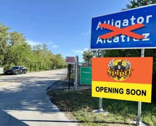 Sign at the entrance to Alligator Alcatraz with "Alligator Alcatraz" crossed out and a Spirit Halloween "Opening soon" sign photoshopped underneath.